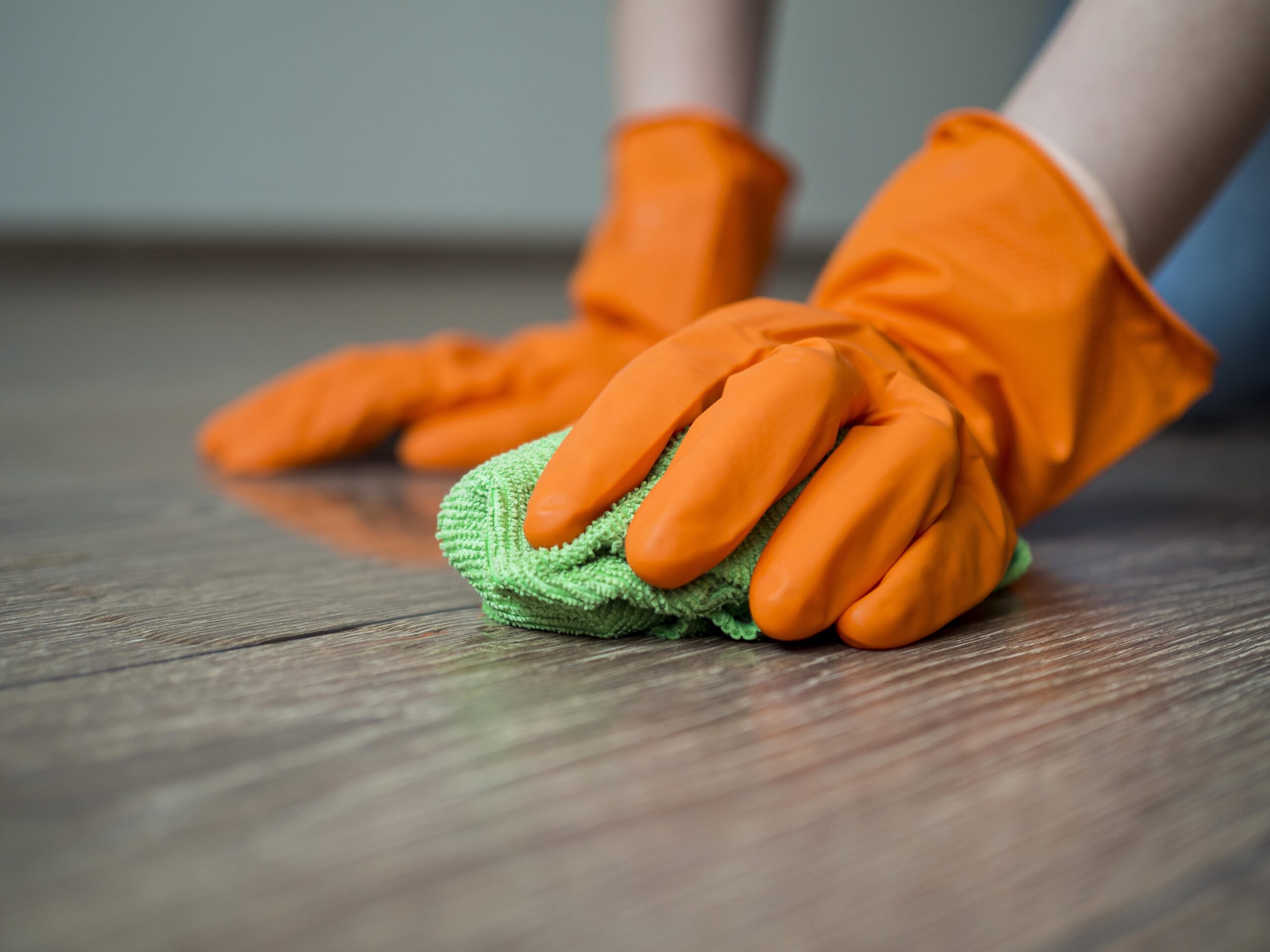 close-up-hands-with-rubber-gloves-cleaning-floor